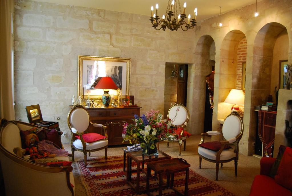 a living room with chairs and a table with flowers at B&B La Closeraie in Vouvray