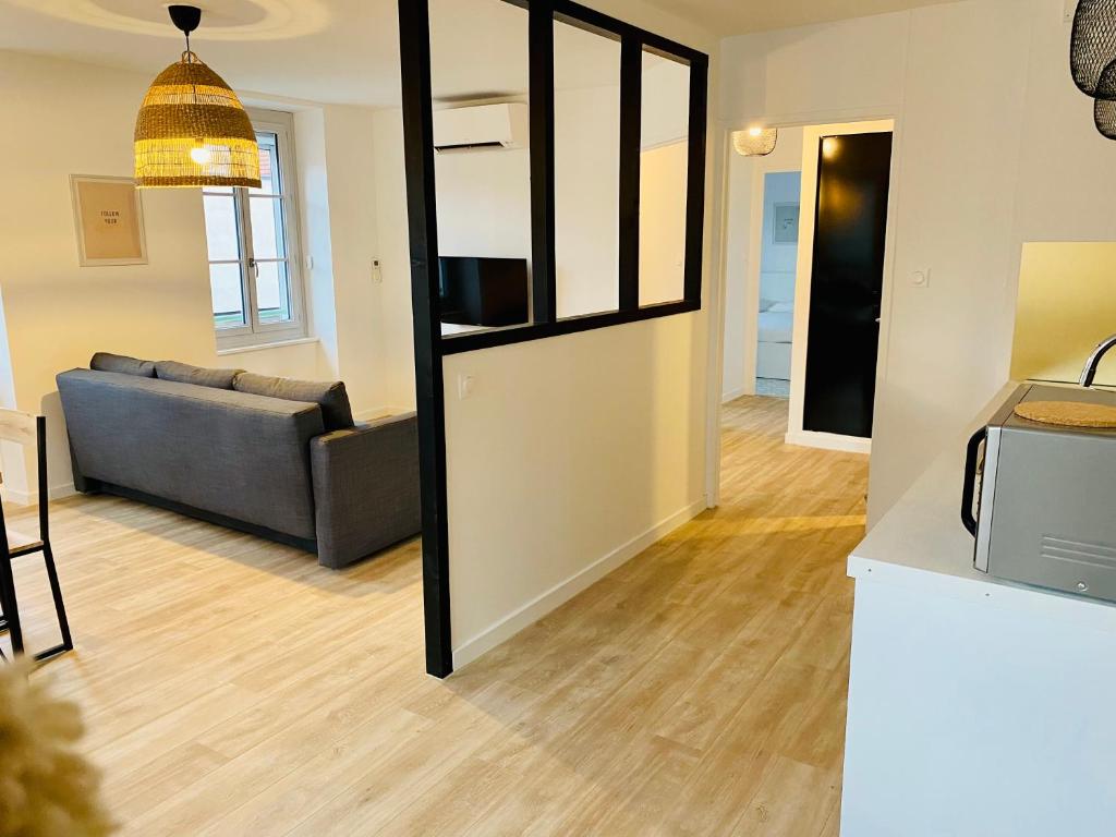 uma sala de estar com um sofá e um espelho em Suite 24 Appart'hôtel-L'Annexe-3 étoiles em Montceau-les-Mines