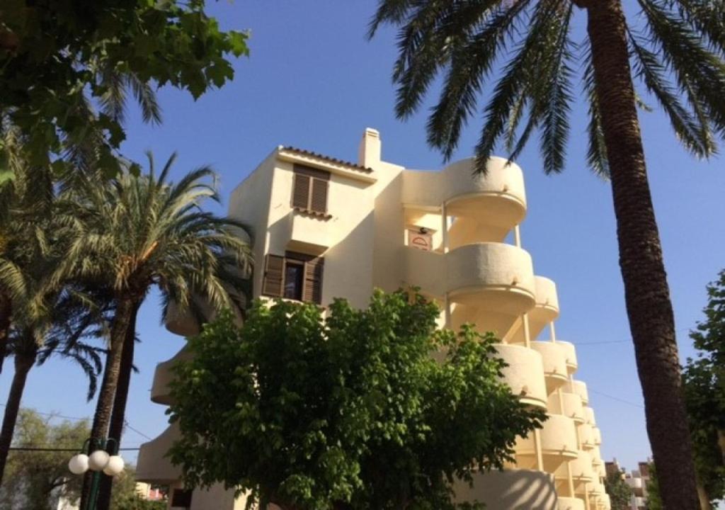 un edificio blanco con palmeras delante en Apartment Gloria, en Denia
