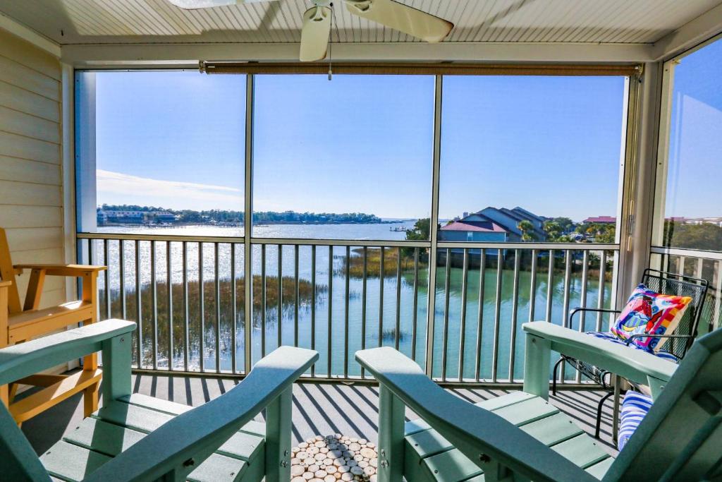 un porche cubierto con sillas y vistas al agua en Hello Sunshine, en Charleston