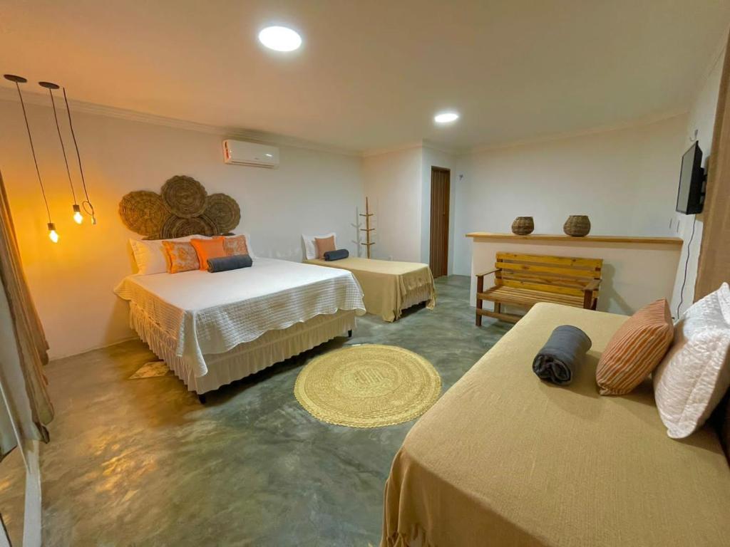 Un dormitorio con 2 camas y un banco. en Pousada Monte das Serras en Serra de São Bento