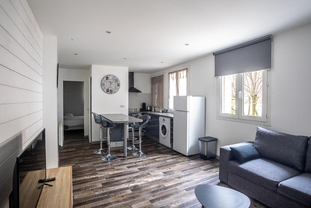 a living room with a couch and a kitchen at Le Saint Louis in Périgueux