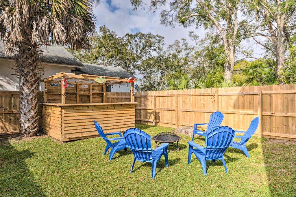 four blue chairs and a table in a yard at Idyllic Pensacola Home with Yard and Fire Pit! in Pensacola