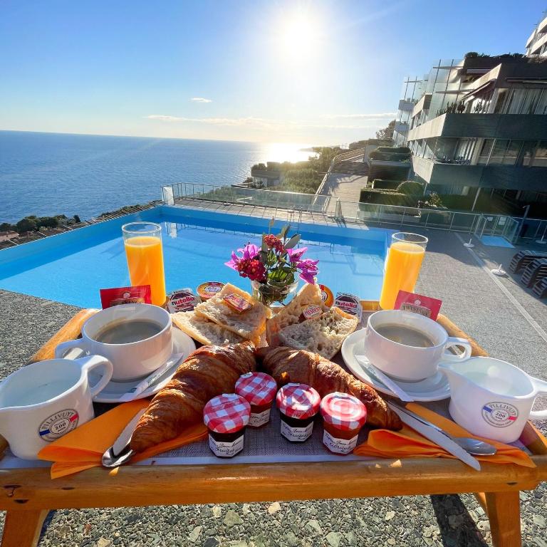 a tray of food on a table next to a pool at SARA RIVIERA Costa Plana in Cap d'Ail