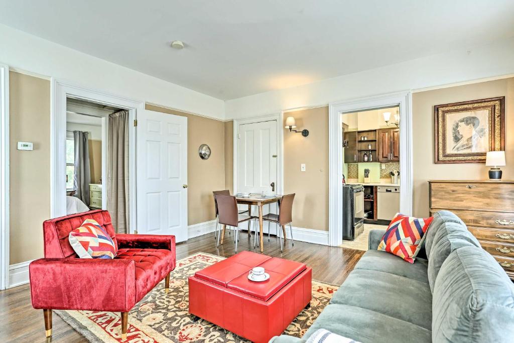 uma sala de estar com um sofá e uma cadeira vermelha em Historic Poughkeepsie Apt - Walkable Location em Poughkeepsie