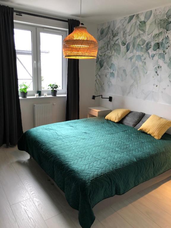 シフィエラドゥフ・ズドルイにあるPrzy Zajęcznikuのベッドルーム1室(大型ベッド1台、緑の掛け布団付)