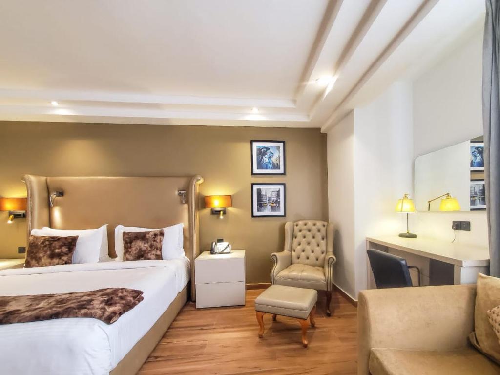 um quarto de hotel com uma cama grande e uma cadeira em Victoria Crown Plaza Hotel em Lagos