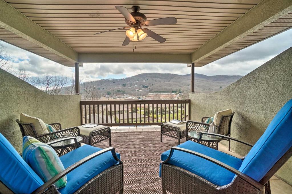 a porch with blue chairs and a ceiling fan at Cozy Young Harris Condo Near Lake Chatuge! in Young Harris