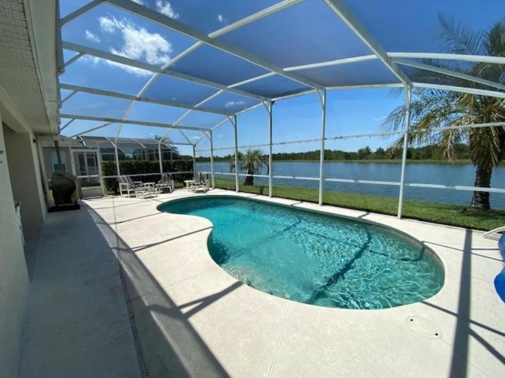 a swimming pool under a pergola on a house at K&K Vacation Homes With Private Pool in Kissimmee