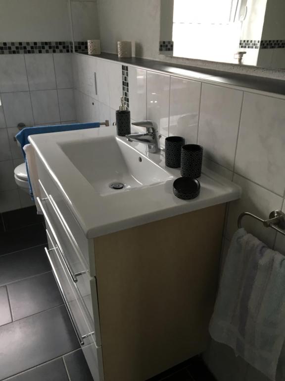 a bathroom sink with two cups on top of it at Haus Ursula 2 in Brake