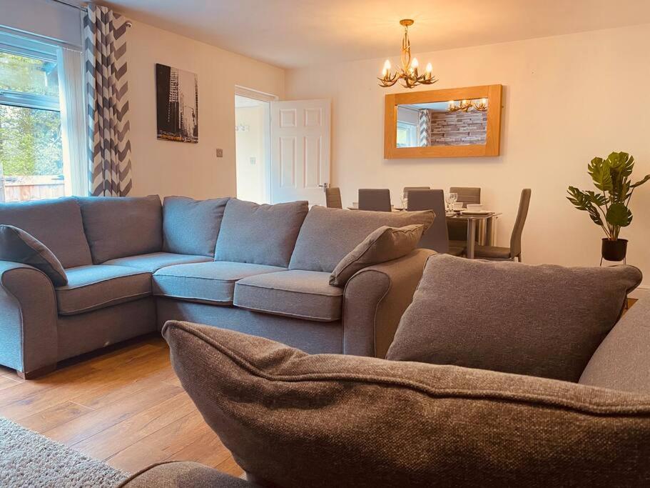 a living room with a blue couch and a table at Comfy House with Parking for Multiple Vehicles in Cardiff