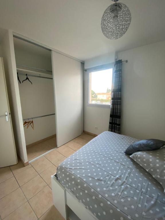 ein Schlafzimmer mit einem Bett und einem begehbaren Kleiderschrank in der Unterkunft Appartement moderne en résidence avec piscine in Mèze