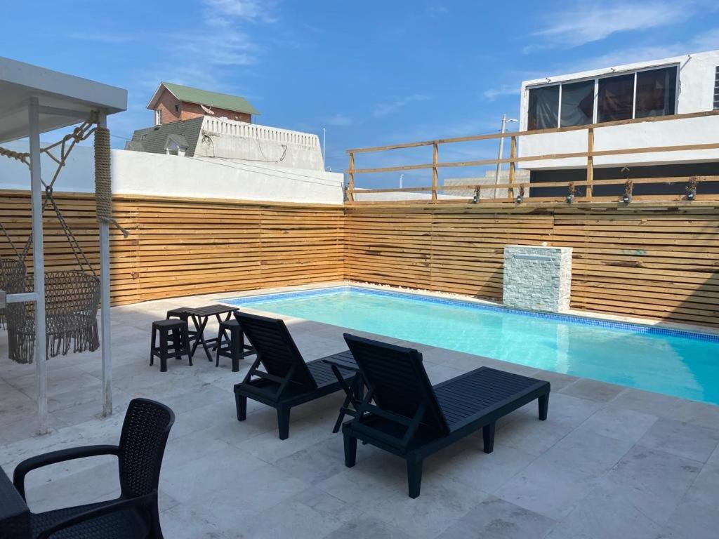 a swimming pool with chairs and a table next to a fence at Apartamentos Frente a La Playa Boca del Rio in Boca del Río