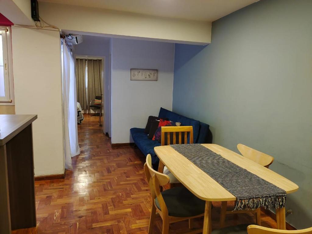 une salle à manger avec une table et un canapé bleu dans l'établissement Nueva Cordoba Funcional, à Córdoba