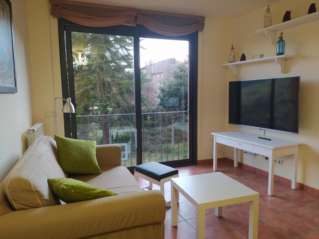 a living room with a couch and a flat screen tv at Apartament dúplex d'una habitació in Borredá