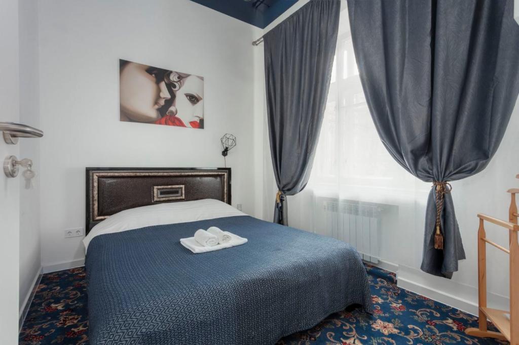 a bedroom with a blue bed and a window at Pushkinskaya "Wine palette" in Kharkiv