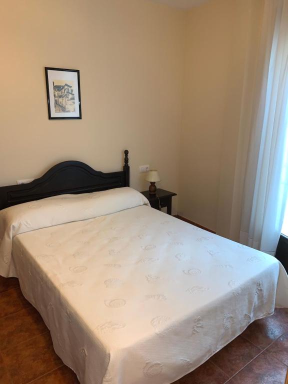 a bedroom with a bed with a white bedspread at Apartamento El Campanario in Zuheros