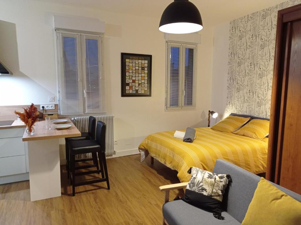 1 dormitorio con cama, escritorio y silla en Le Girond'Inn, en Libourne