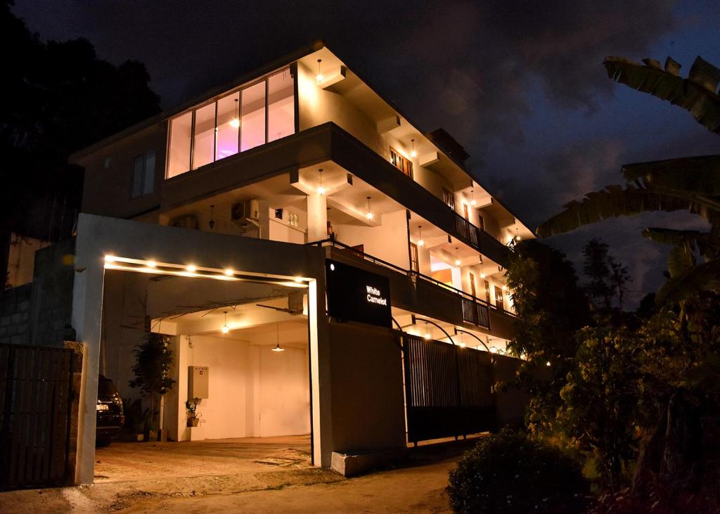 a large building with lights on it at night at White Camelot in Kandy