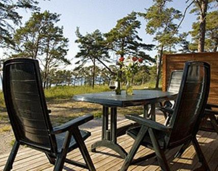 a black table and two chairs on a deck at Lummelunda Stugor in Visby