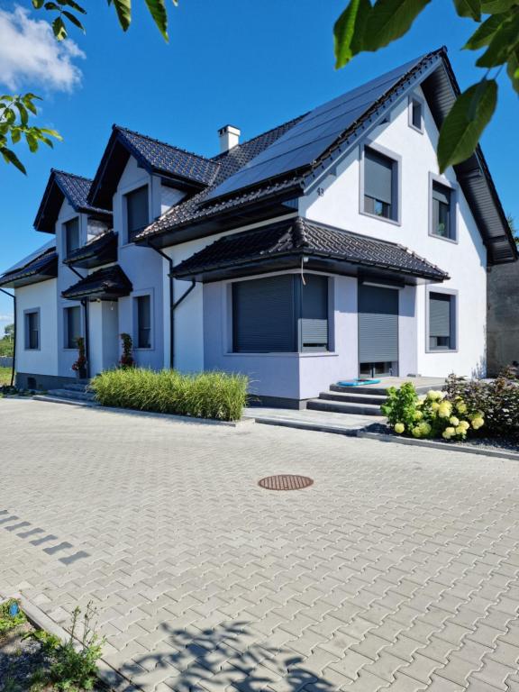 a house with a solar roof on a driveway at Noclegi 24/h Leszczynek in Kutno