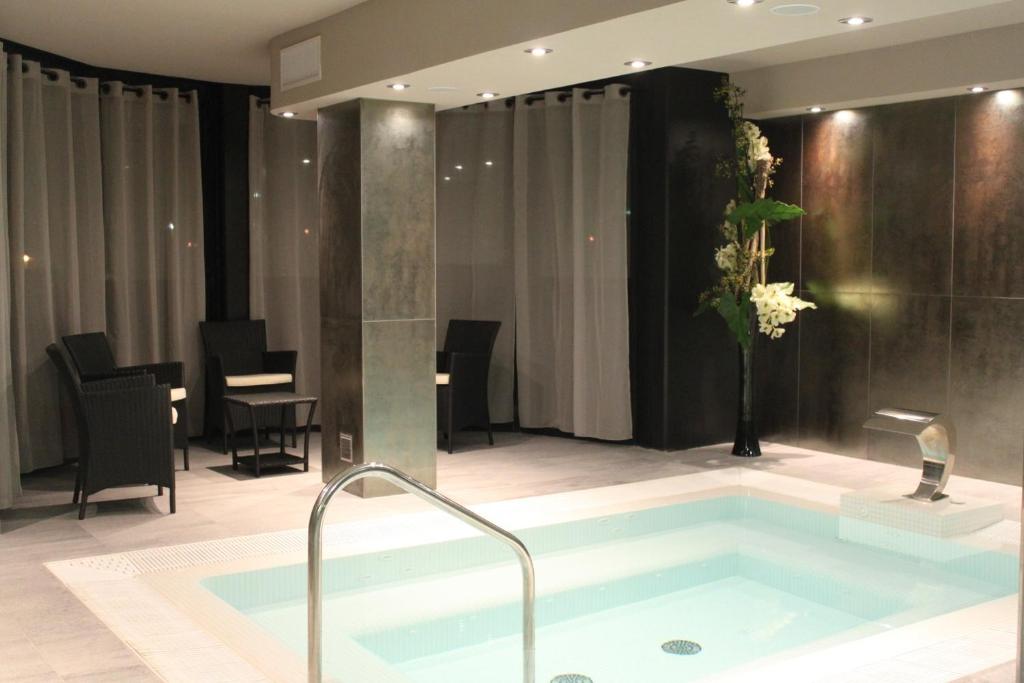 a bathroom with a bath tub in a room at Hotel Palladia in Toulouse