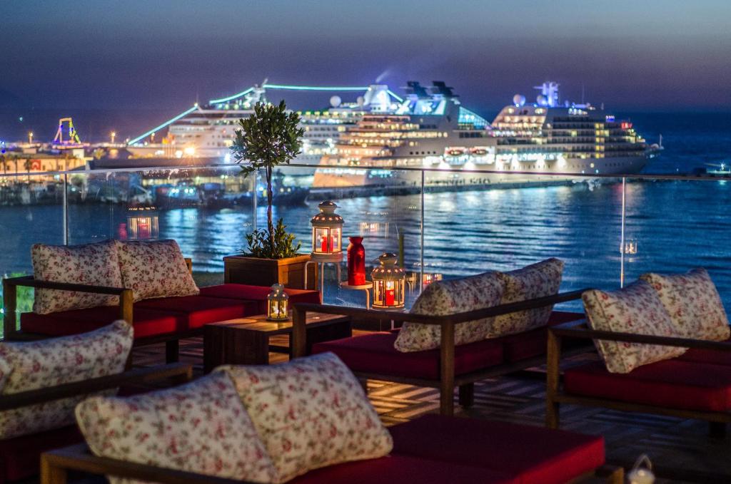 a restaurant with a cruise ship in the water at night at Ilayda Avantgarde Hotel in Kuşadası