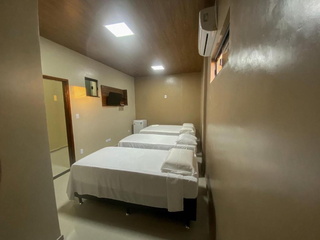 eine Reihe von vier Betten in einem Krankenhauszimmer in der Unterkunft HOTEL LISBOA in Capanema