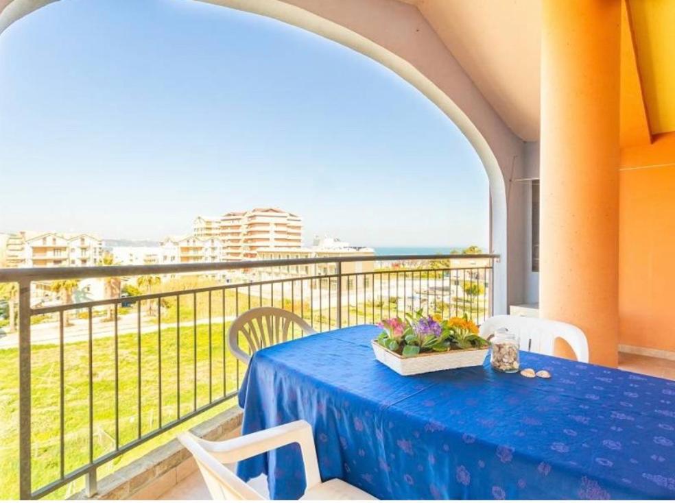 - une table bleue sur un balcon avec vue sur l'océan dans l'établissement Punta Ovest a due passi del MARE, à Marina di Montenero