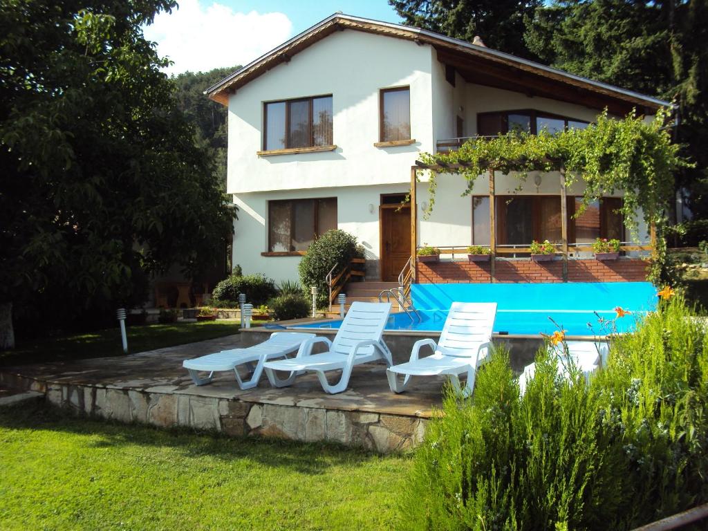 uma villa com piscina em frente a uma casa em House Mirlevi em Shipka