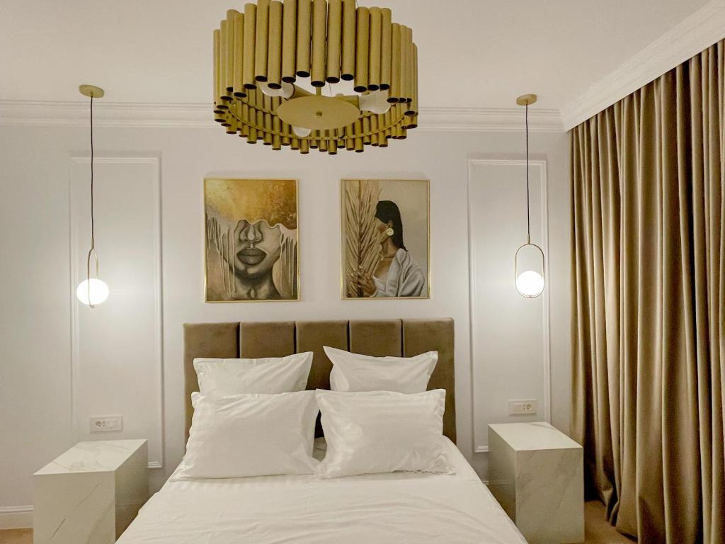 um quarto com uma cama e um lustre em Selling Sunset Apartments em Timisoara