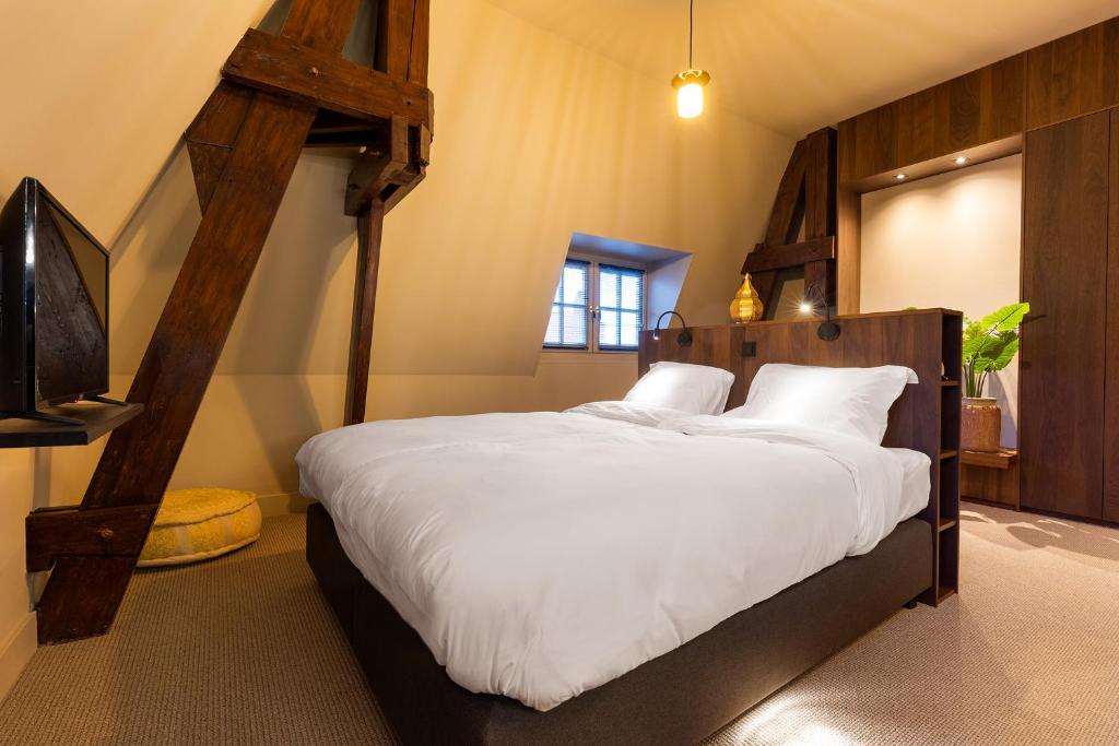 a bedroom with a large bed with white sheets at New Park Edition in Venlo