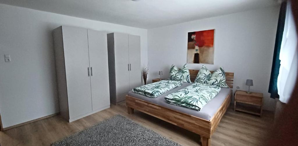 a bedroom with a bed and a white cabinet at Hortensia - Appartment - Ferienwohnung - Ferienhaus in Münzkirchen