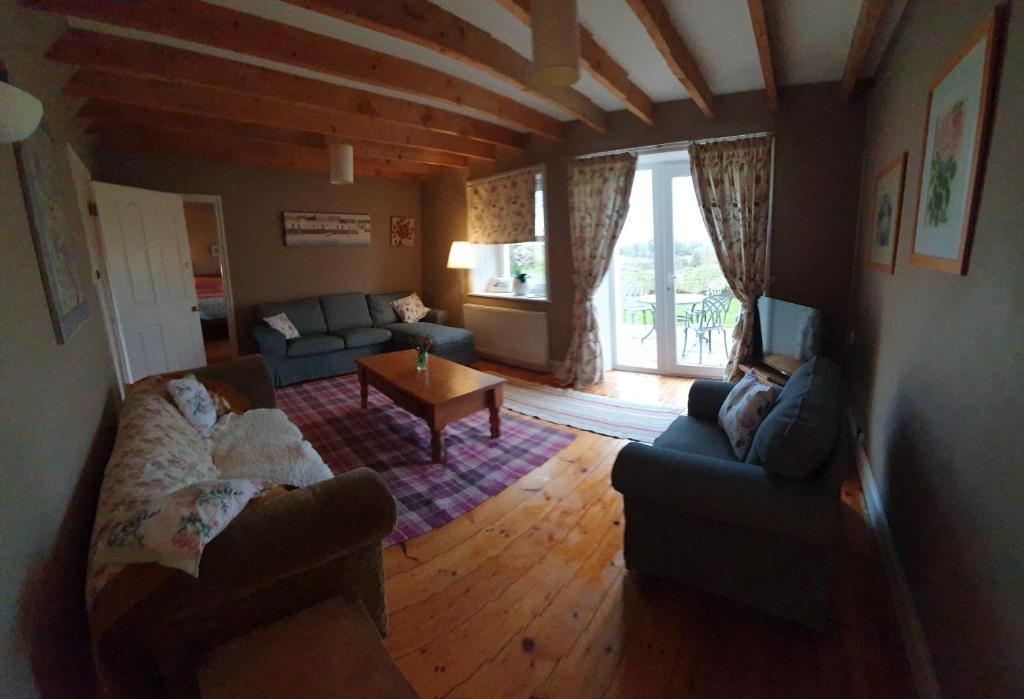 a living room with a couch and a table at Barcloy Honey House in Kirkcudbright