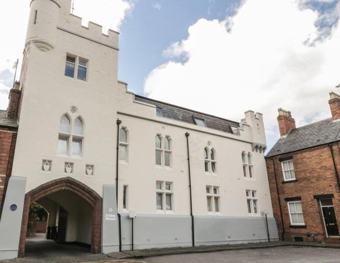 a large white building with an archway in a street at The Penthouses, 9 Albion Mews in Chester