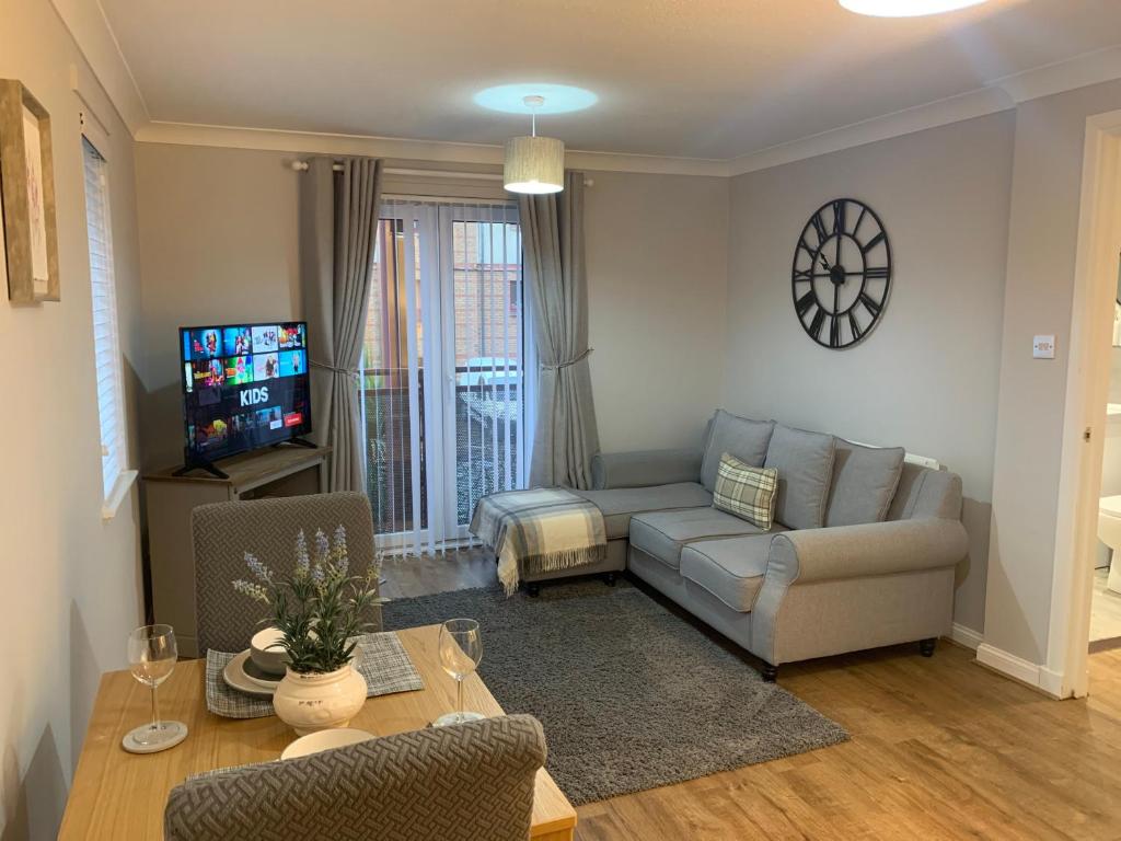 a living room with a couch and a table at Kinfirth Apartment in Ayr