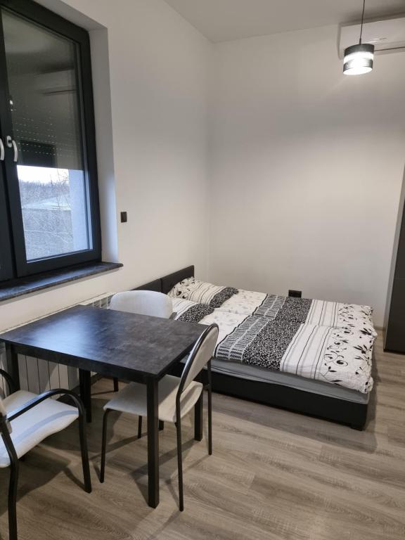 1 dormitorio con 1 cama, mesa y sillas en Noclegi 24/h Leszczynek en Kutno