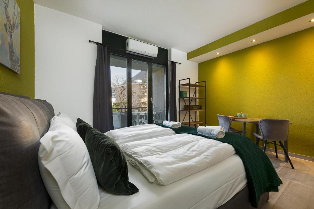 un letto in una camera con parete gialla di Monolocale con terrazzo vista lago Via Cassarinetta 7 by LR a Lugano