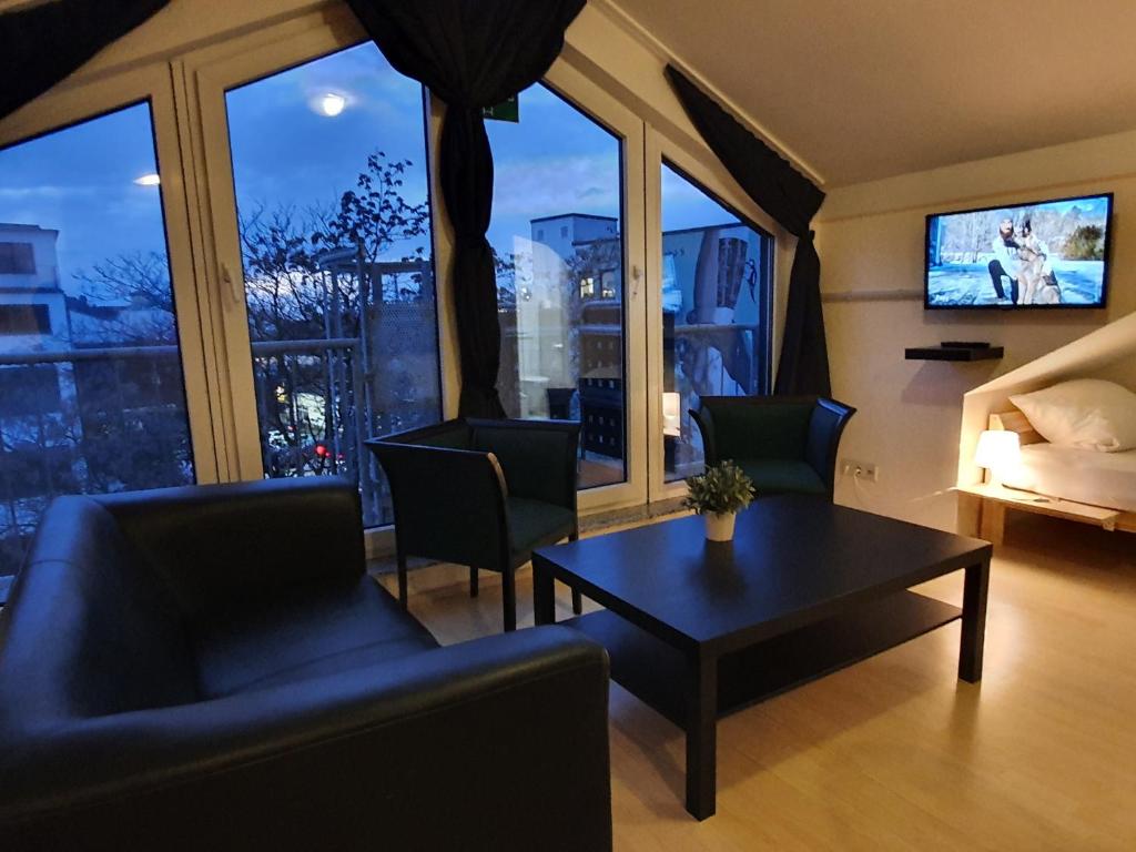 a living room with a couch and a table in front of a window at CityPark Aparthotel in Cologne