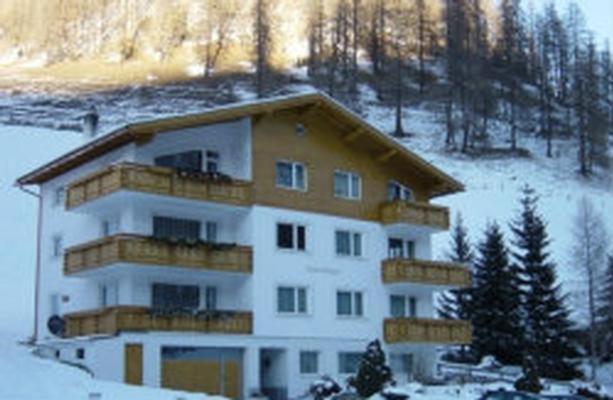 a large apartment building in the snow with trees at Chasa Mezpra/Pfister-Jenal Nr. 1 - Ferienwohnung für 2-4 Personen in Samnaun