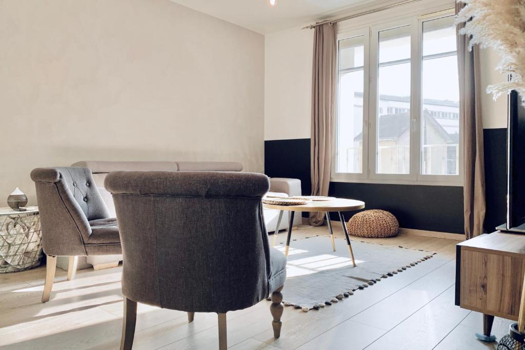 un salon avec une chaise et une table dans l'établissement #CK Doux voyage Main streets, à Grenoble