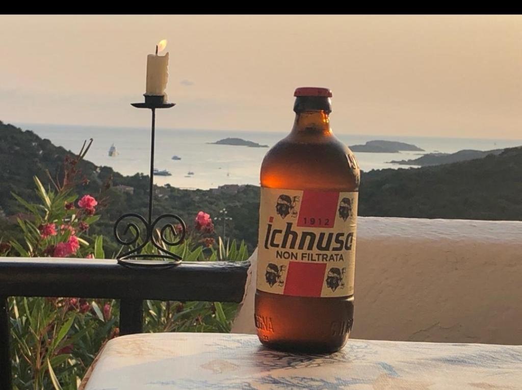 butelka piwa na stole ze świecą w obiekcie Appartamento Taras Sottovento - Porto Cervo w mieście Abbiadori