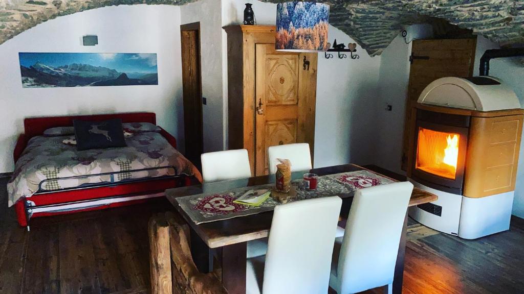 奧斯塔的住宿－La Cachette CIR 0001，一间卧室配有一张床、一张桌子和一个壁炉