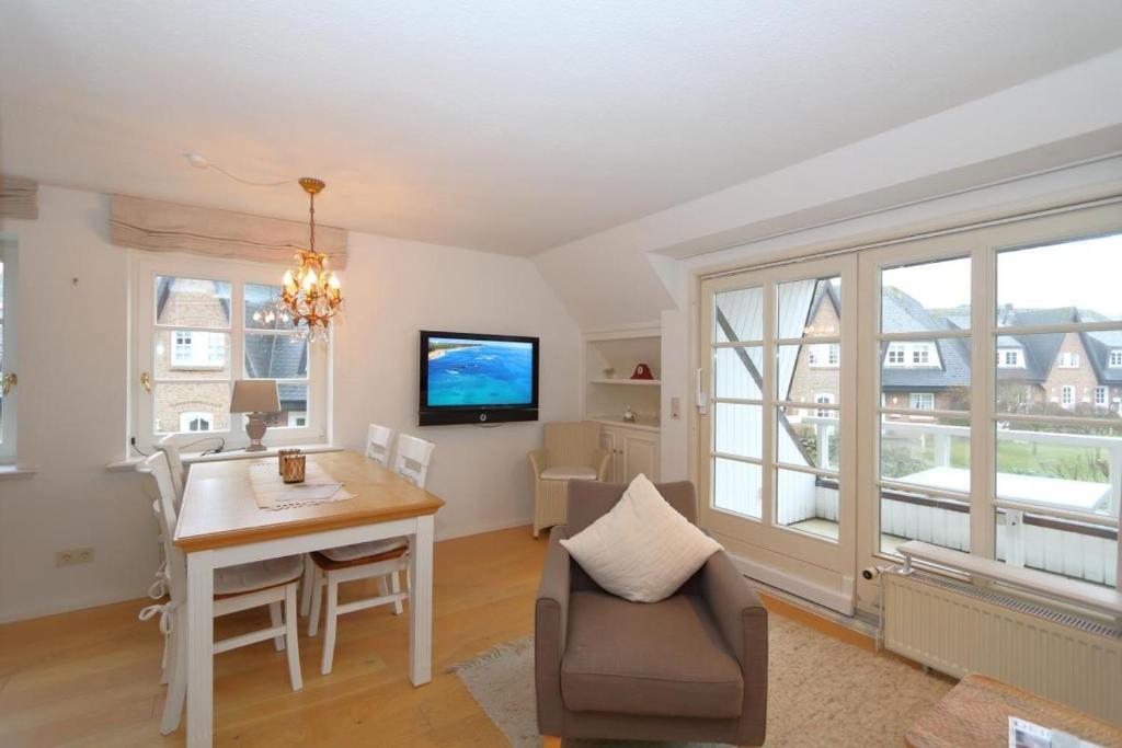 a living room with a dining room table and a tv at Ferienwohnung-Krause in Munkmarsch