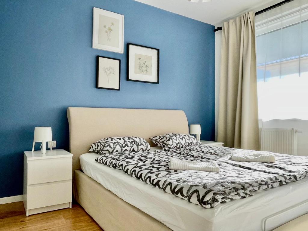 1 dormitorio con paredes azules y 1 cama con almohadas en Historical Beer - Stein, en Bratislava