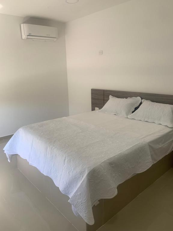 a bedroom with a white bed with white sheets at Hotel Wanderlust in Santa Marta