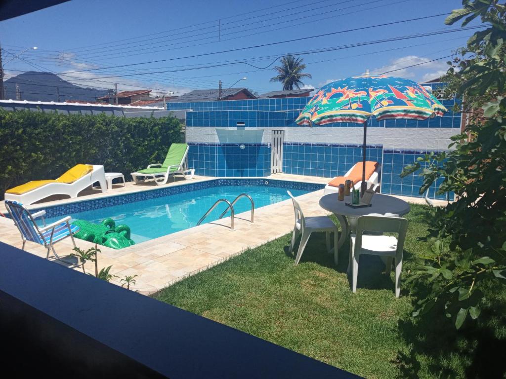 - Piscina con mesa y sombrilla en Casa dos Prados, en Peruíbe