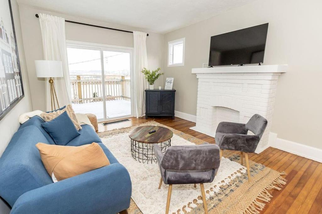 sala de estar con sofá azul y chimenea en Cozy Riverfront Bungalow with Stunning Views en Covington
