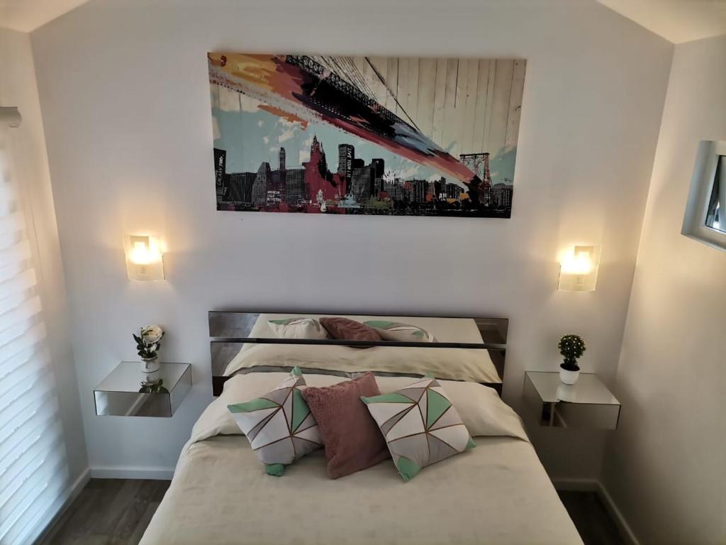 a bedroom with two beds and a painting on the wall at cabaña emilia house in Punta Arenas
