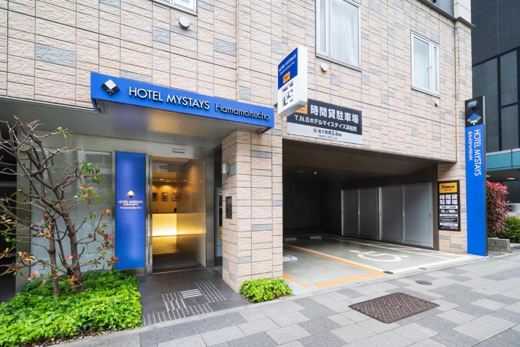 a hotel entrance with a sign on a building at HOTEL MYSTAYS Hamamatsucho in Tokyo